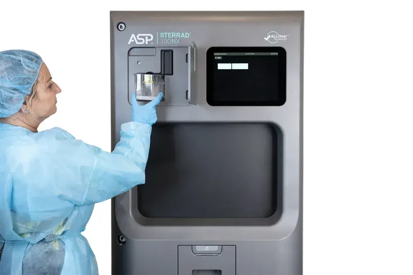 Woman removing disposable cassette box from STERRAD 100NX Sterilizer